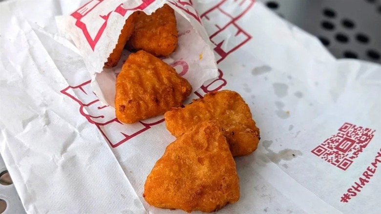 Several Sheetz mac and cheese bites next to the bag