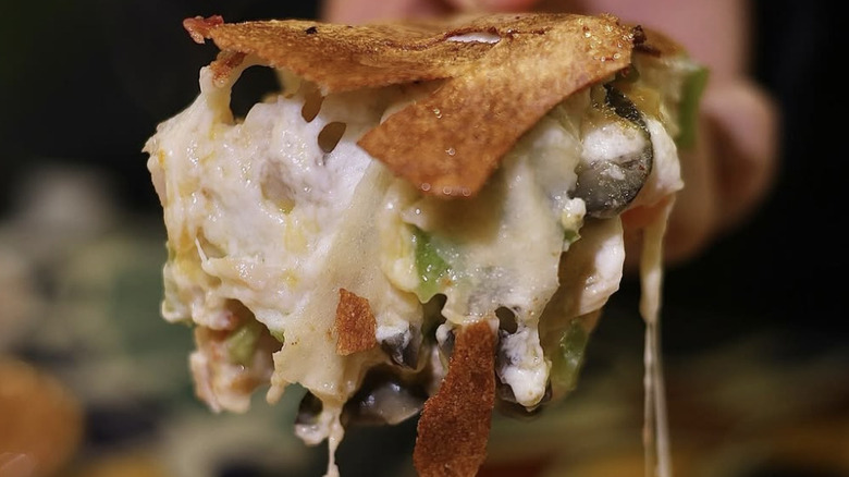 Slice of feteer dripping with cheese and vegetables