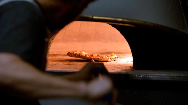 Pizza being put into oven