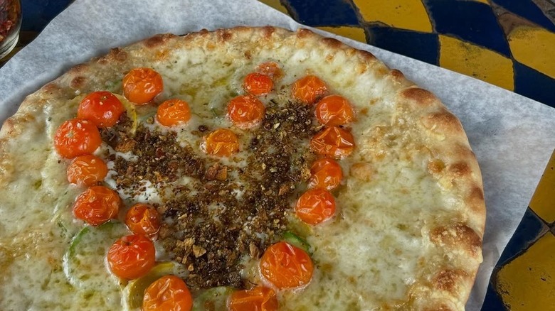 White pizza topped with heart shaped tomatoes
