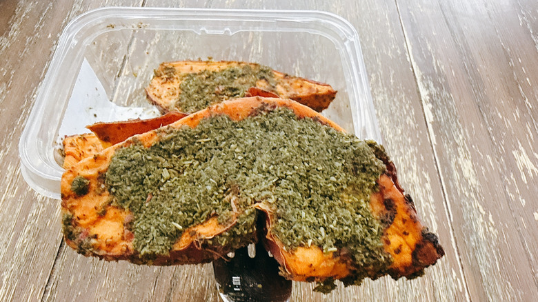 Whole Foods garlic herb sweet potato with the container in the background on a wooden table