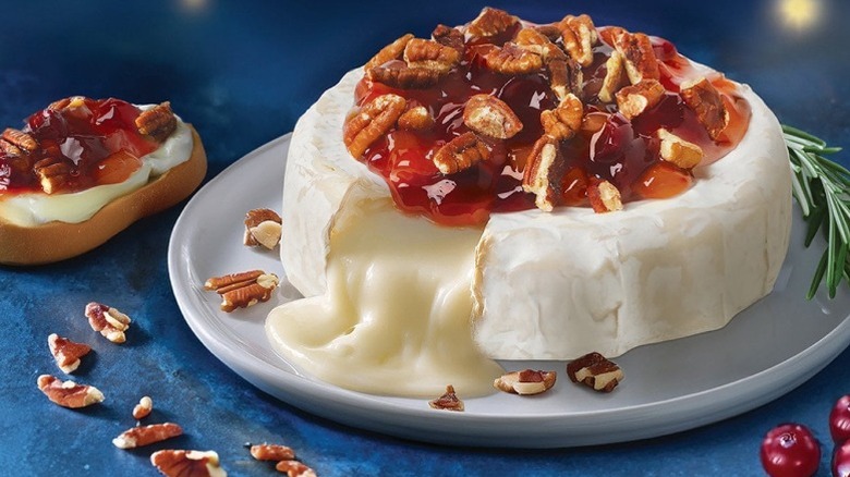 brie cheese topped with fruit and nuts