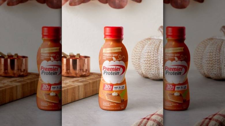 Premier Protein pumpkin pie protein shake with a knitted white pumpkin and a copper cup