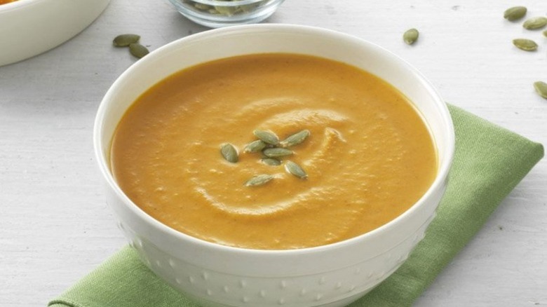squash soup in a white bowl on a green napkin