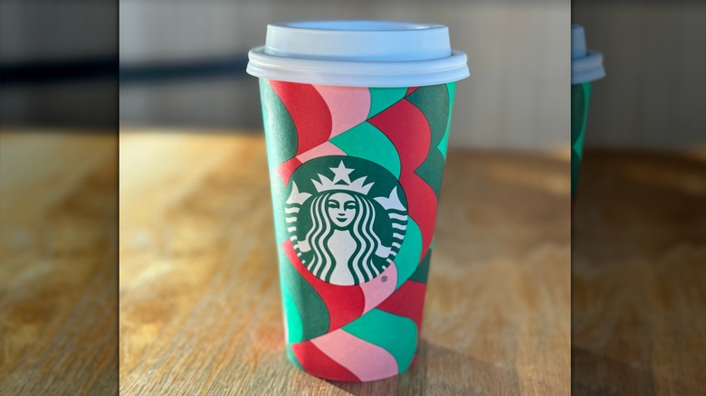 A hot tea cup from Starbucks sits on a table