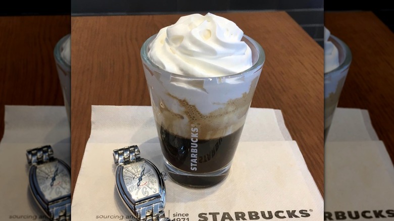 An espresso con panna sits on a napkin