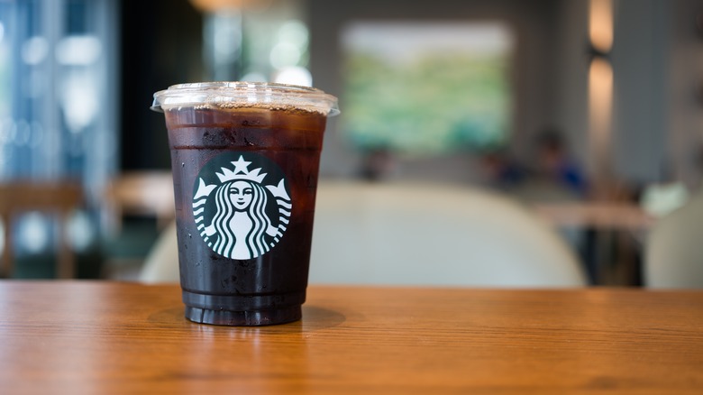 An iced Americano from Starbucks sits on a table