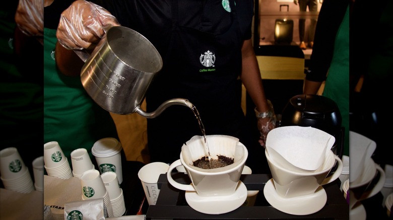 A barista pours water into a filter of Pike Place coffee