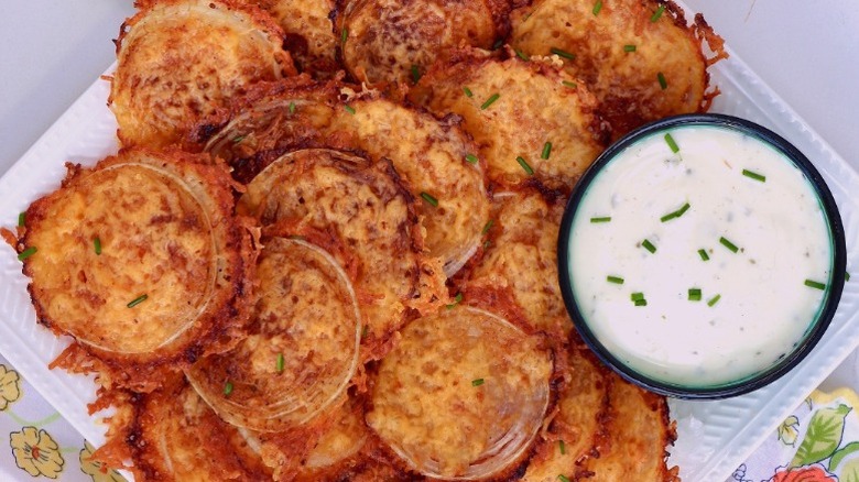 onion chips on a plate with a bowl of white dip