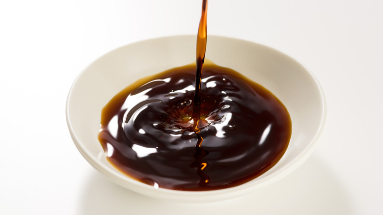 Pouring soy sauce into white bowl