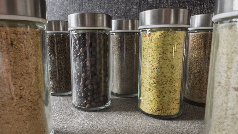 Glass jars of spices in a cabinet