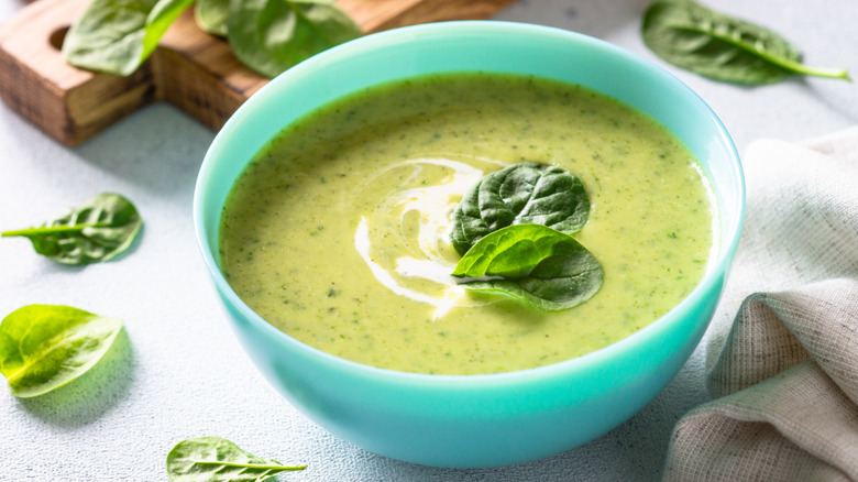 Green soup with spinach in a blue bowl