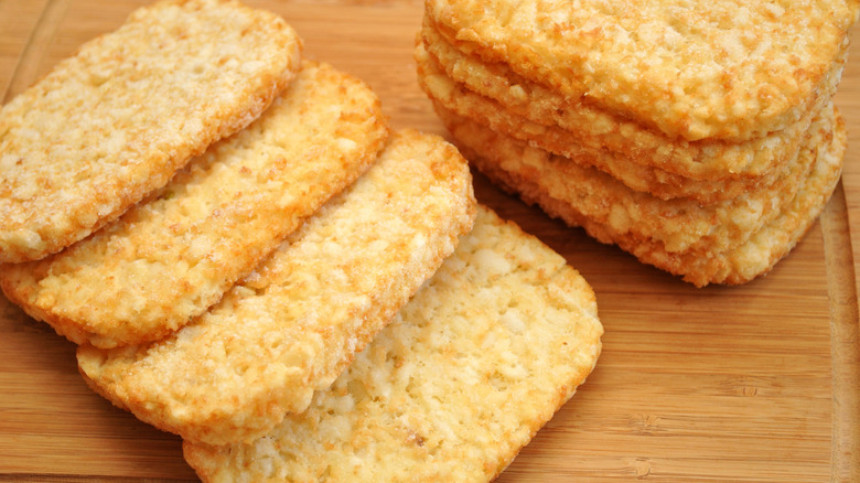 Frozen hashbrown patties on wooden board