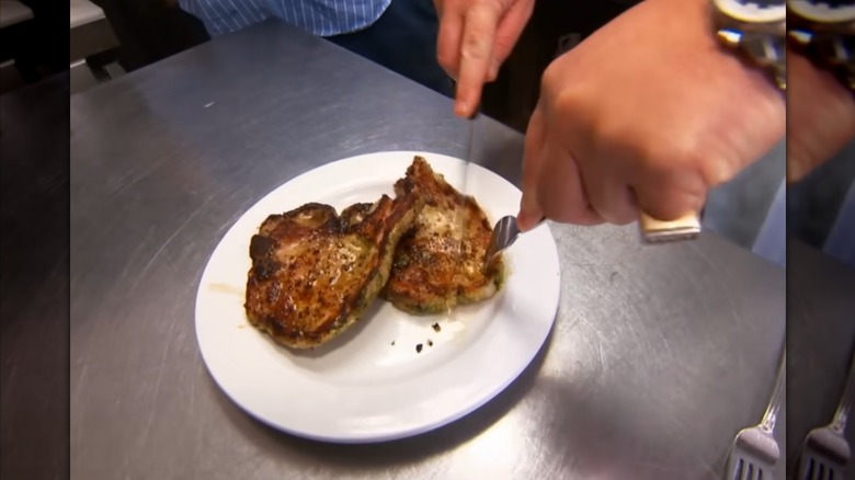 Guy Fieri cutting into pork chops