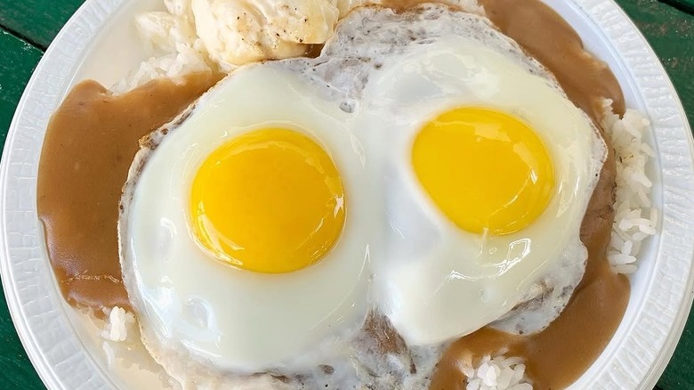 A plate of loco moco on a green table