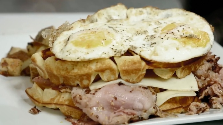 Waffle Madame topped with eggs and meat