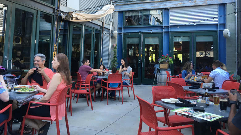 Patrons dining at tables on the outdoor patio of a Salt Lake City restaurant