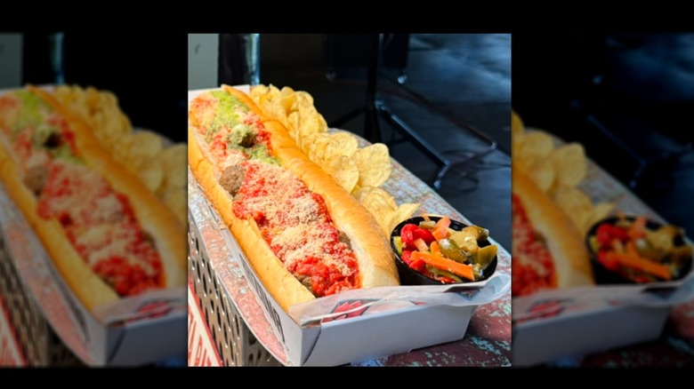 Grand Slamwich in cardboard canoe with potato chips on the side