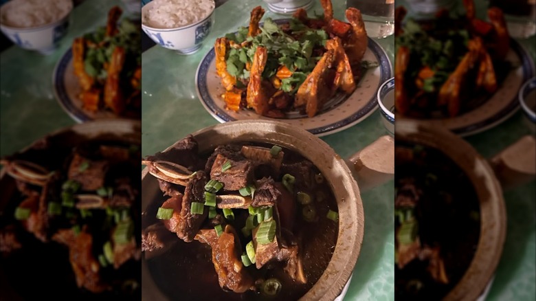 Rice and meat dishes arranged in platters on a green table.