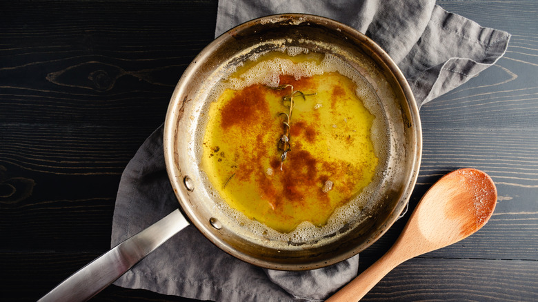 Brown butter infused with fresh rosemary in a stainless steel skillet