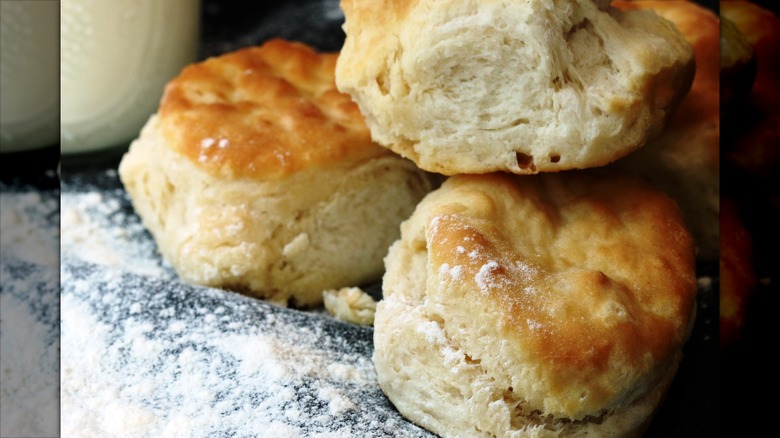 Stack of homemade golden Biscuits on cloth with flour