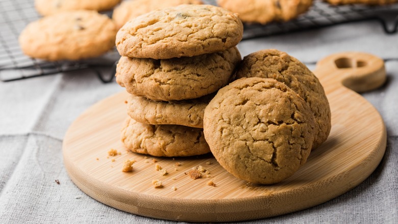 Peanut butter cookies stacked on circular wooden cutting board