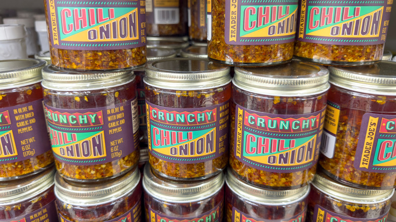 Jars of the Crunchy Chili Onion condiment stacked in towers on Trader Joe's shelves