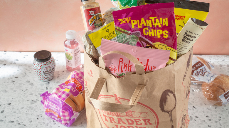 trader joe's brown paper shopping bag on counter with assorted groceries