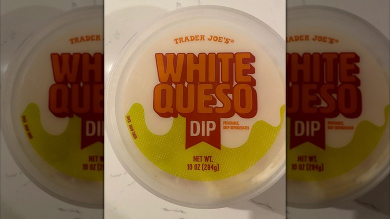Small plastic tub of Trader Joe's white queso dip on countertop