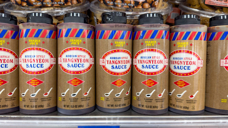 Squeeze bottles of Trader Joe's Yangyeom sauce in line on store shelf