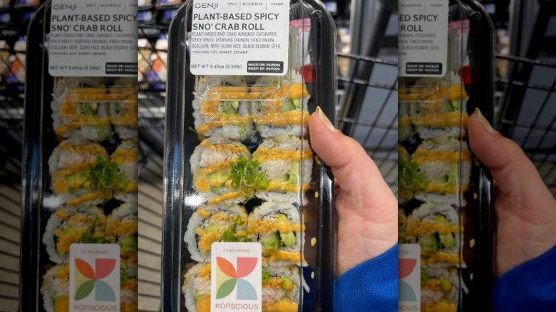 Hand holding a package of vegan sushi that reads plant-based spicy sno' crab roll