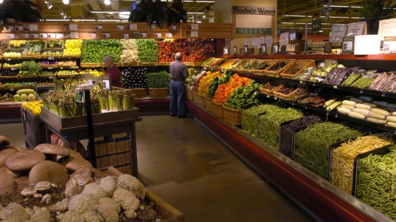 Produce section inside of Whole Foods Market with two shoppers