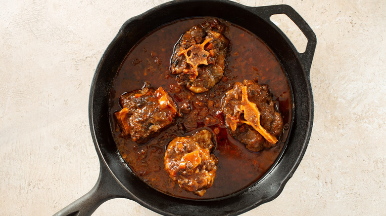 Top view of braised oxtails in cast iron skillet