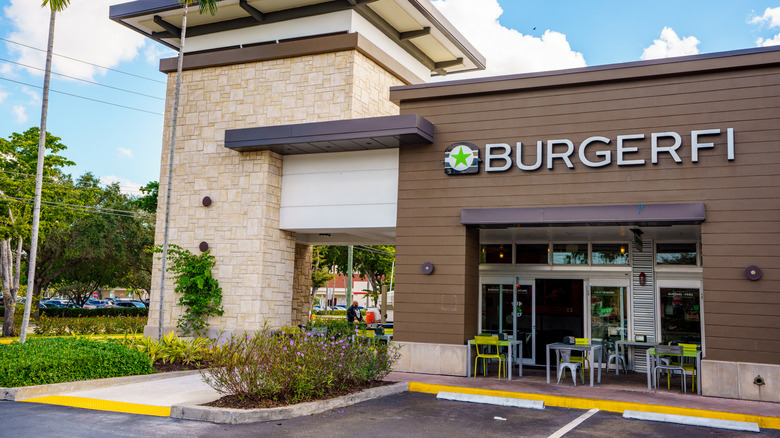 BurgerFi restaurant exterior in front of some small outdoor tables and empty parking lot