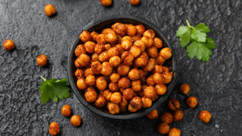 Roasted spicy chickpeas in rustic wooden bowl.