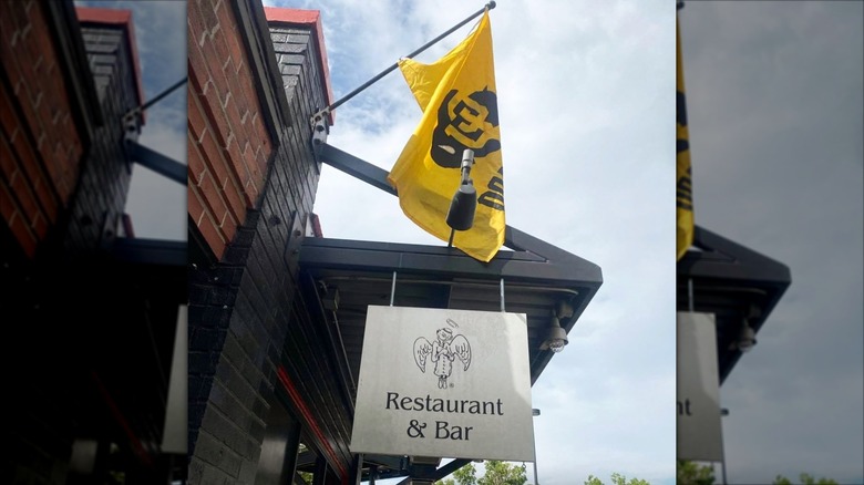 The Sink exterior with a CU Boulder flag flying above the entry