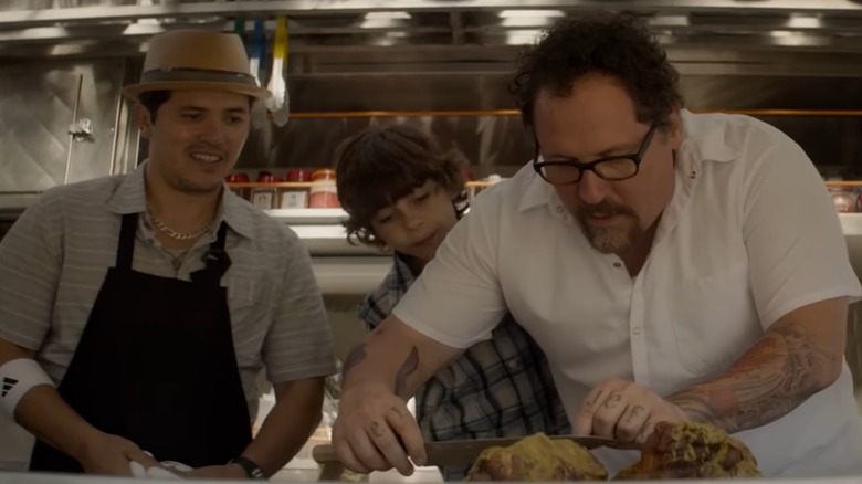 Emjay Anthony, John Leguizamo, and Jon Favreau cooking a meal in "Chef"