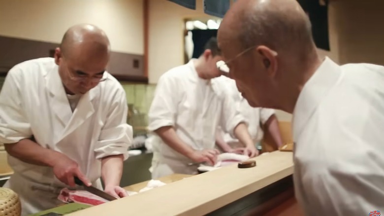 Jiro Ono and two other sushi chefs working at a sushi bar in "Jiro Dreams of Sushi"