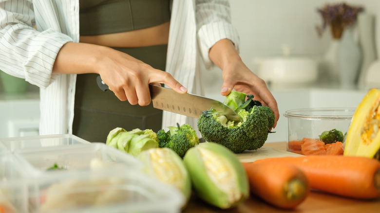 A woman cutting fresh broccoli