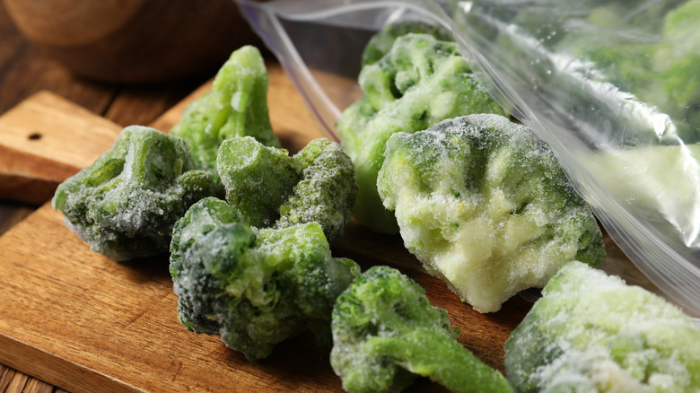 Frozen broccoli on a wooden cutting board