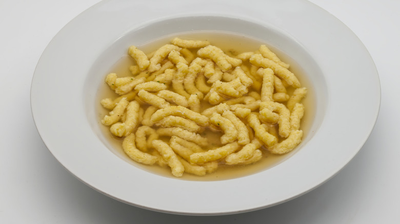 Pasta in parmesan broth in a white bowl