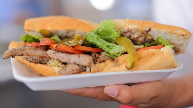 A person holds a traditional Mexican sandwich called Torta