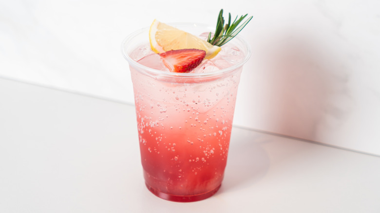 Fizzy strawberry lemon Italian soda with rosemary sprig
