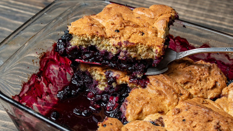 A glass dish of blueberry cobbler made with boxed cake mix and butter