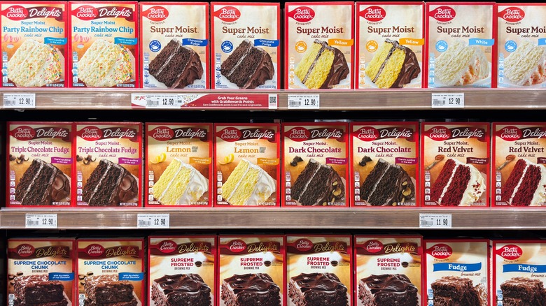 Boxes of cake mix in various flavors on grocery store shelves