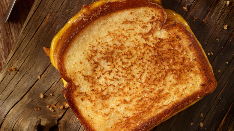 A grilled cheese sandwich on a wooden surface