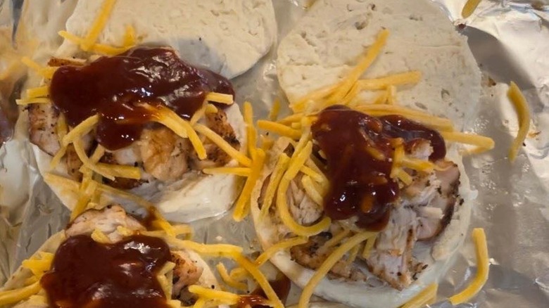 Raw biscuit dough with BBQ sauce, shredded cheese, and chicken