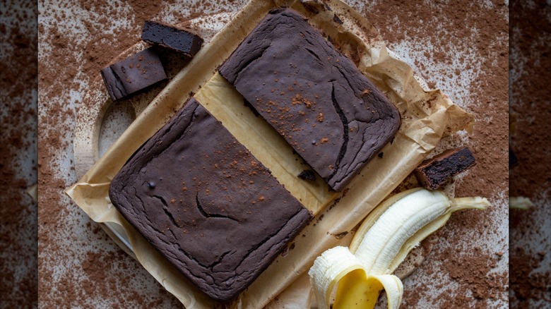Top view of brownies next to a peeled banana