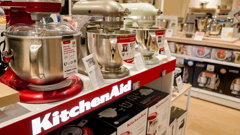 Row of colorful KitchenAid stand mixers on display at store