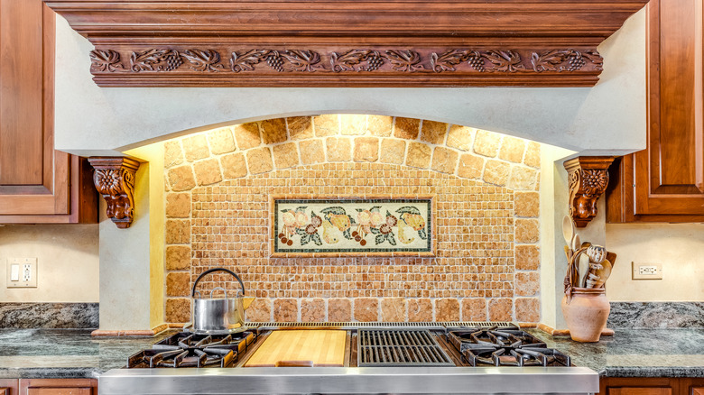 A luxury kitchen with a stainless steel Viking cooktop and decorated hood